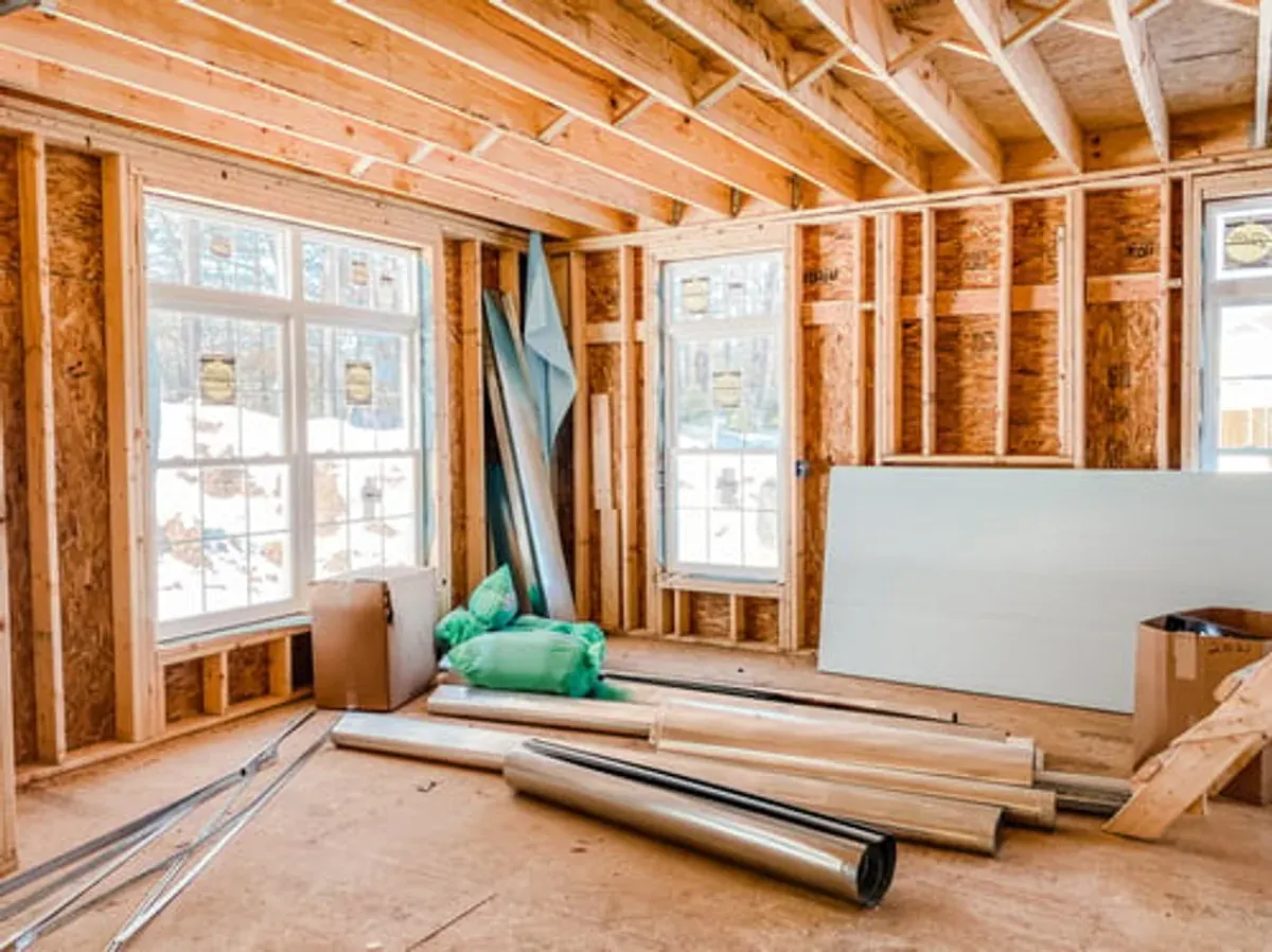 Framed interior of a Big Bear mountain home mid-renovation with snow visible through new windows