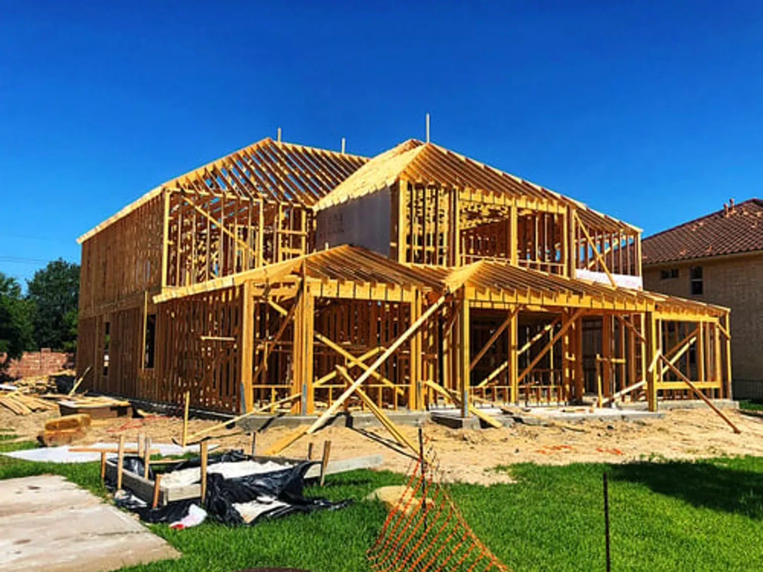 Custom home under construction with full timber framing against a clear blue sky in Big Bear Lake, California