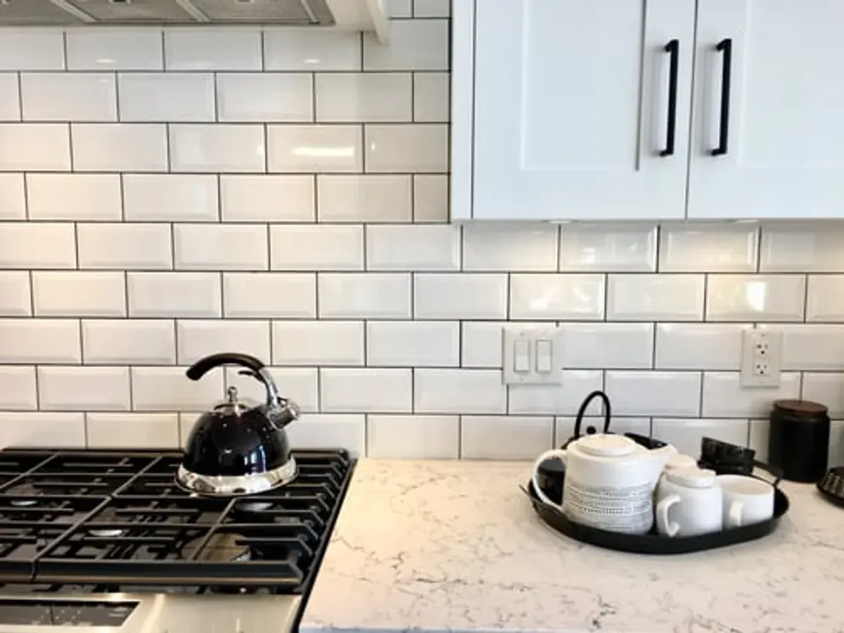 Remodelled kitchen with white subway tile backsplash, quartz counters and shaker cabinets in Big Bear Lake